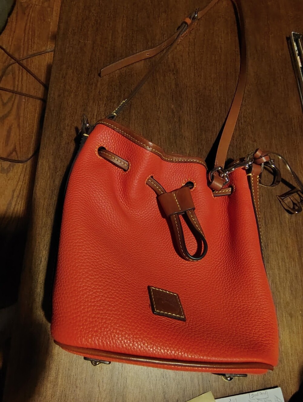 Dooney & Bourke bucket bag in pebble leather. Orange
